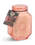 A pink tinted glass candle jar with a sleek glass lid, labeled 'Saffron Rose' from the Botanica collection.