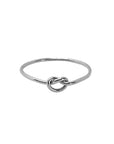 A sterling silver stacking ring with a knotted design on a white background