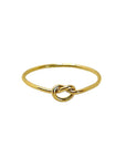 A gold-filled stacking ring with a knotted design on a white background